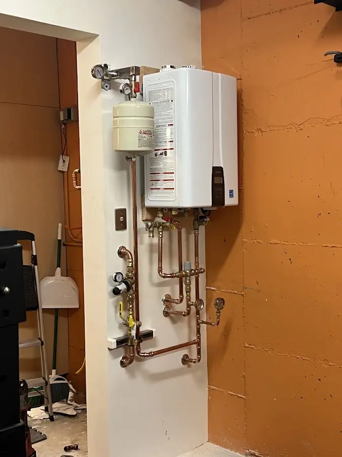 Plumbing technician inspecting water heater connections in Providence Village